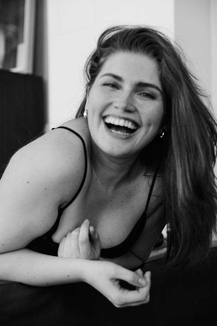 portfolio-img-01 Grayscale portrait of a plus-size woman laughing joyfully indoors.
